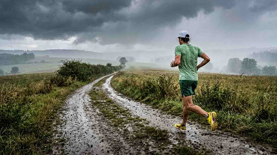 Läufer beim Training auf nassem Weg im Herbst